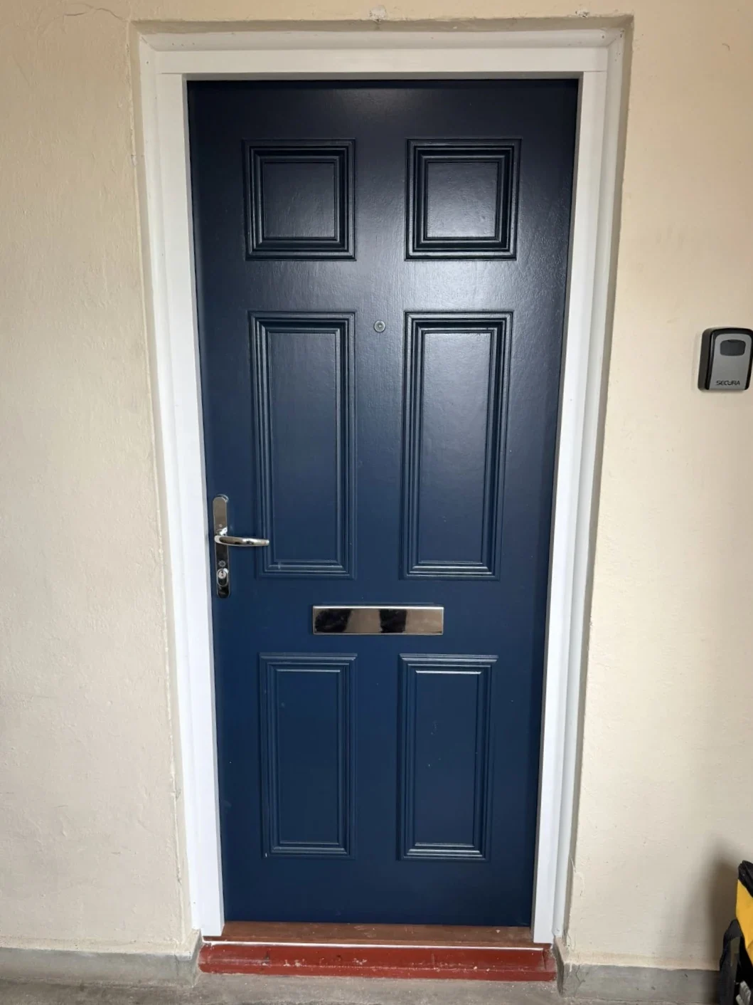 Blue panelled residential entrance door with a letterbox