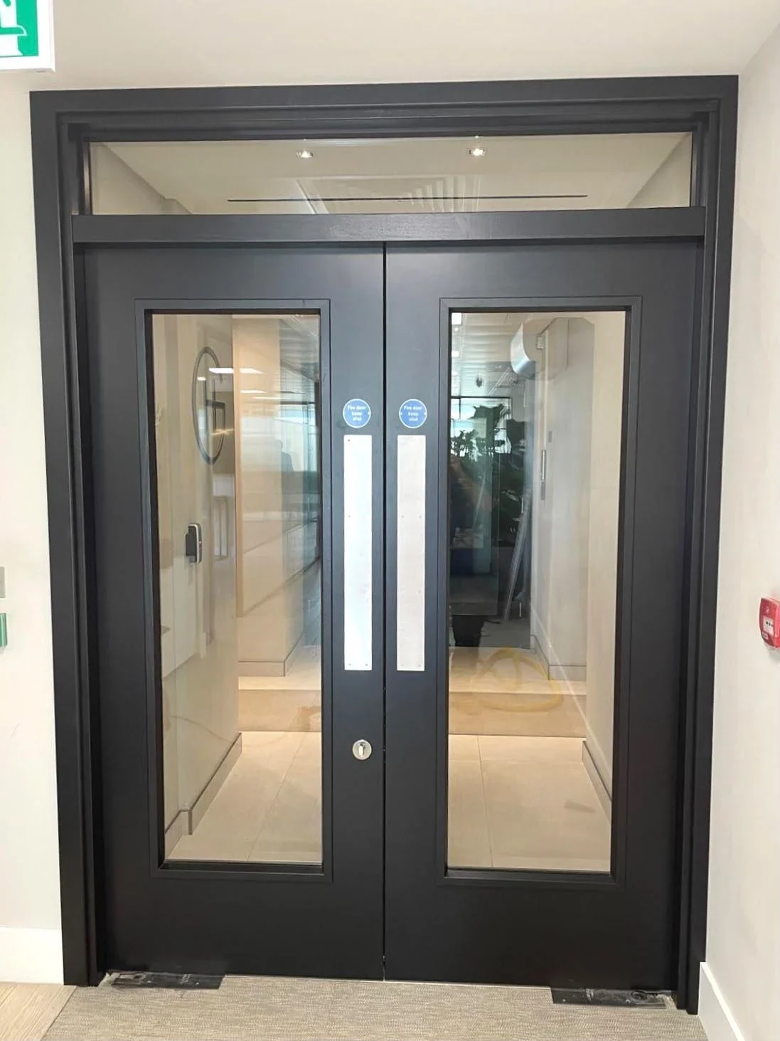 Installed dark glazed double doors with a matching overpanel
