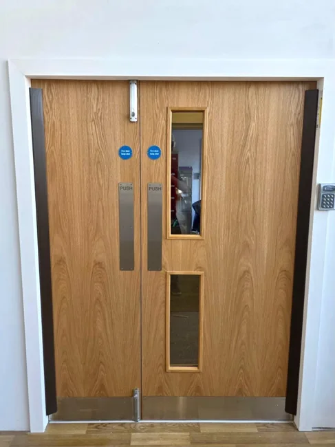 Timber-finish unequal double doors with a glazed panel