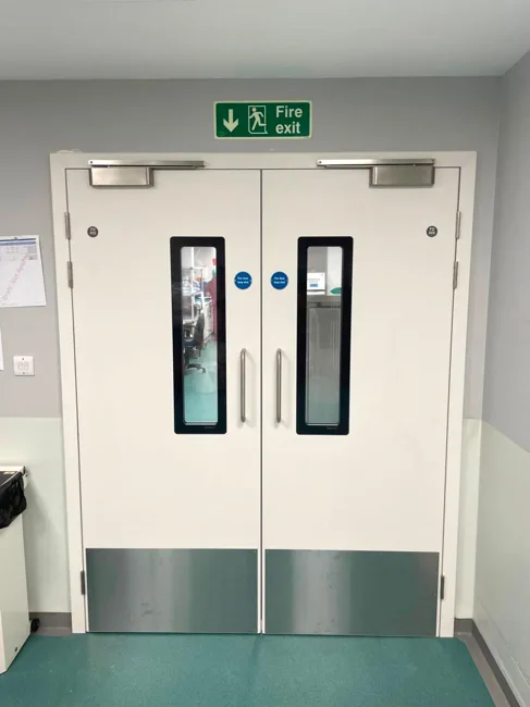 White double doors with vision panels and metal kick plates